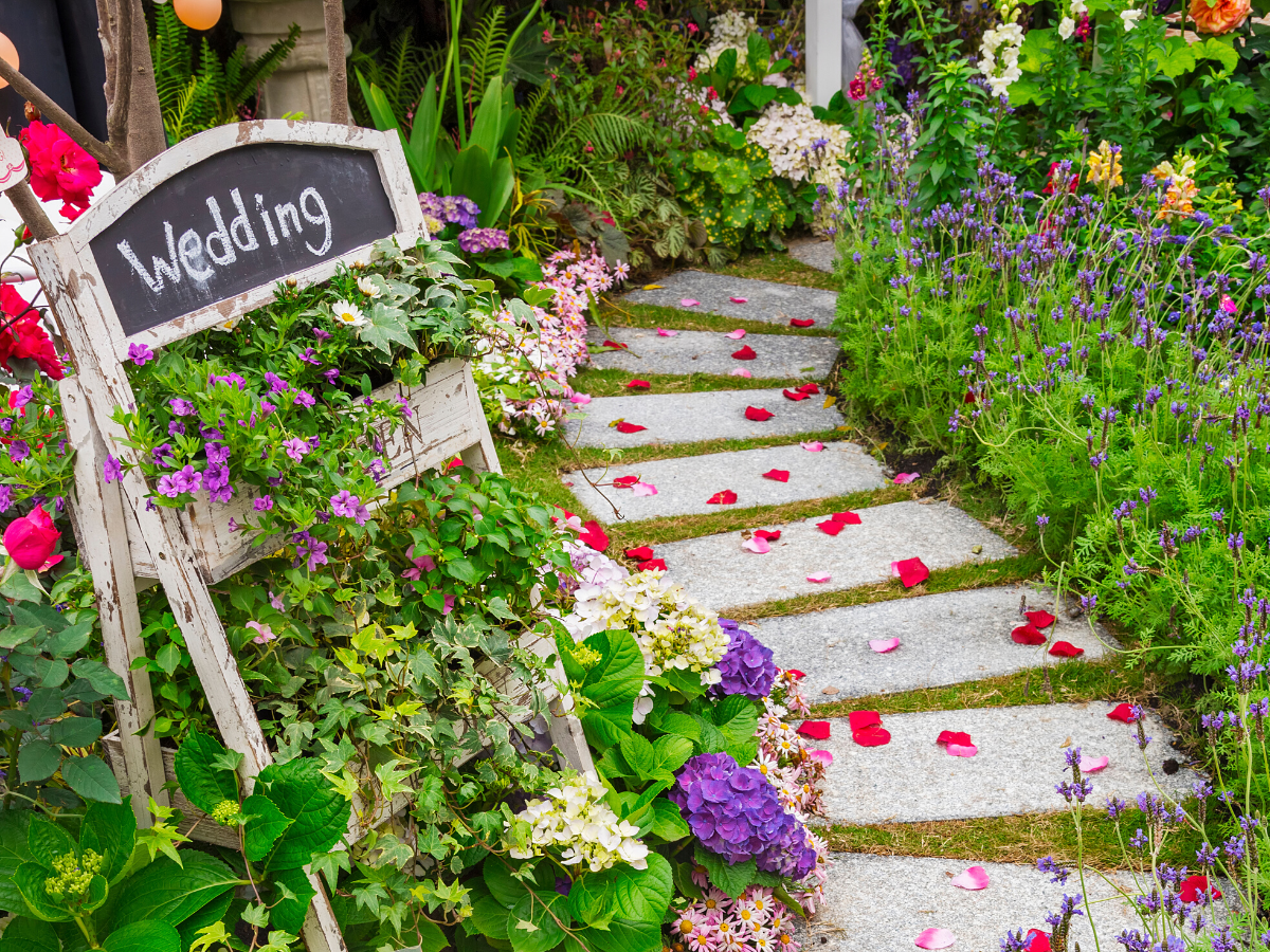 garden path with sign on wooden chair that reads "wedding"