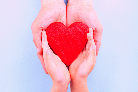 two sets of hands holding heart